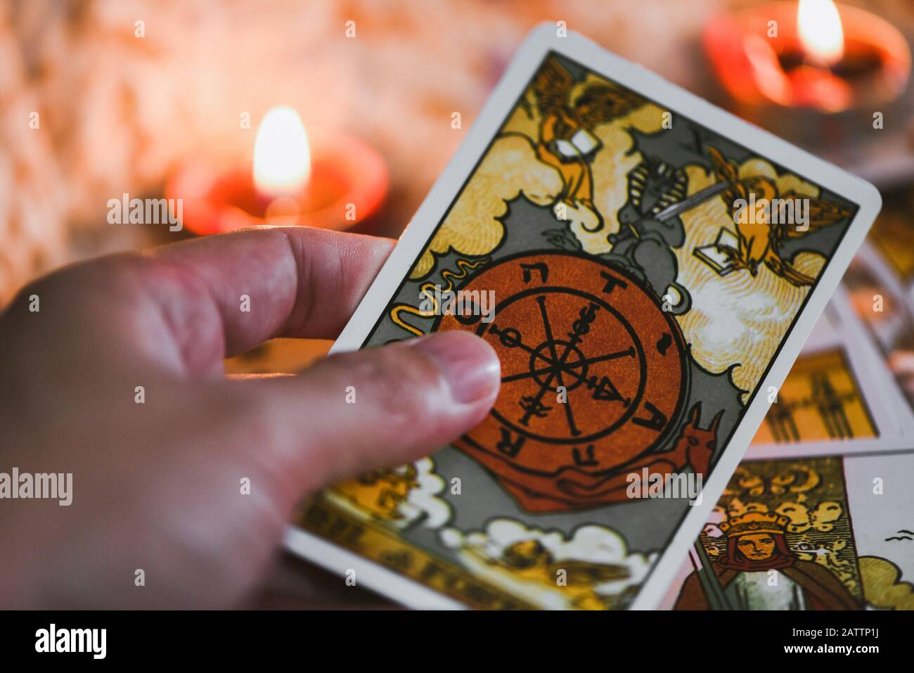 Tarot cards in hand for tarot reading with candlelight background