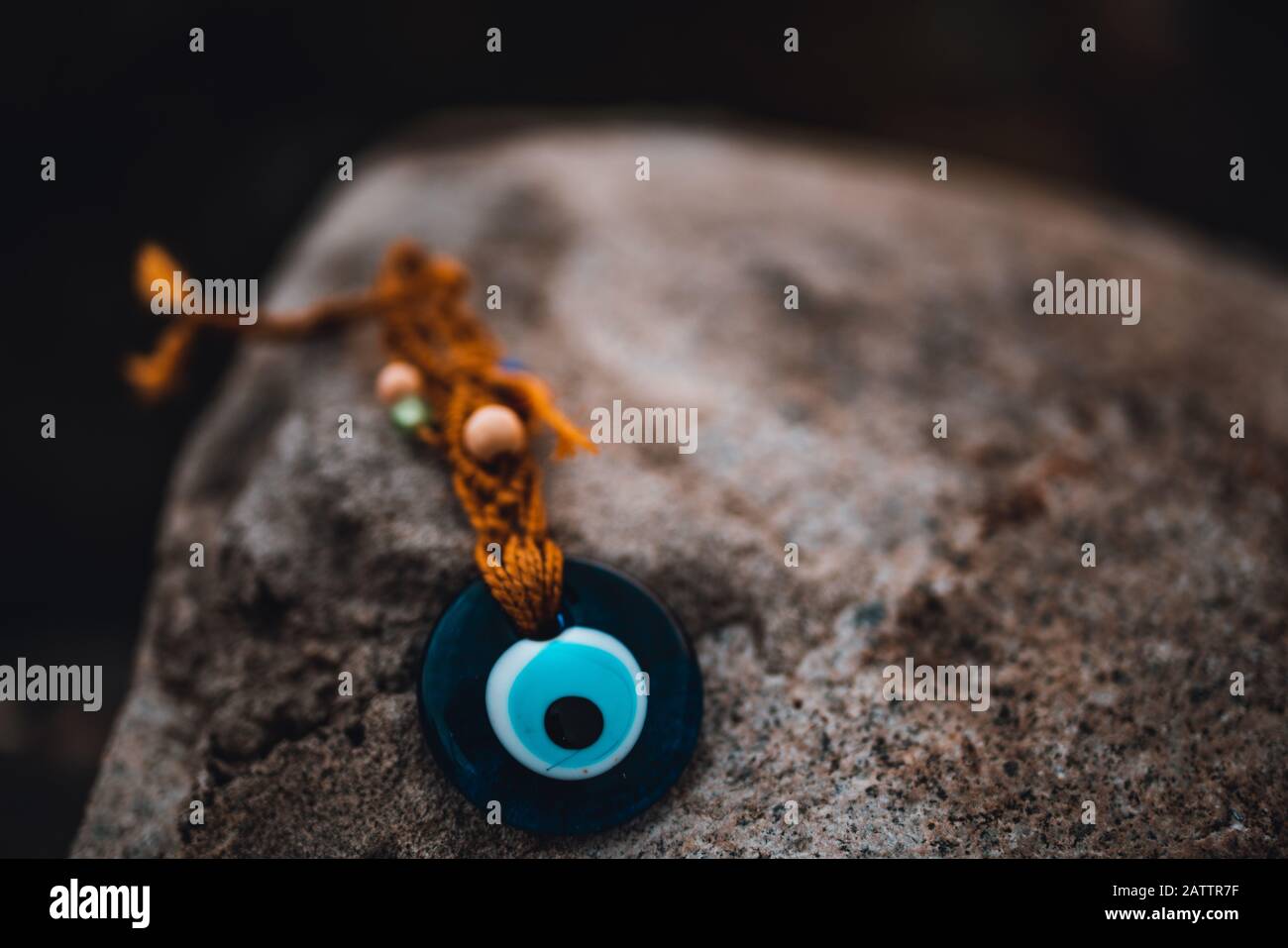 Beautiful evil eye bead on the rock. Culture Concept. Stock Photo