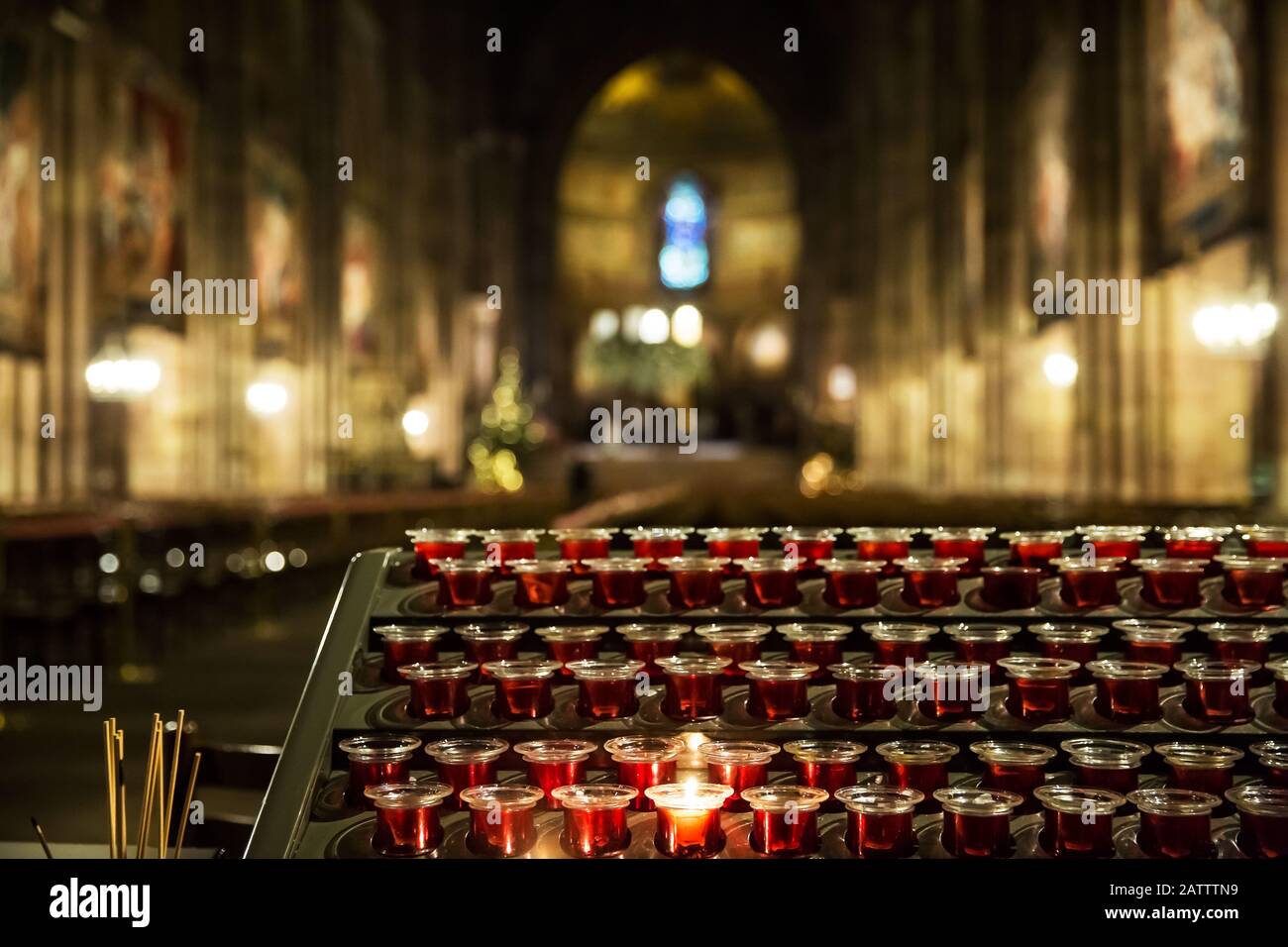 Lighting candles in a catholic temple . Candles are lit near the altar