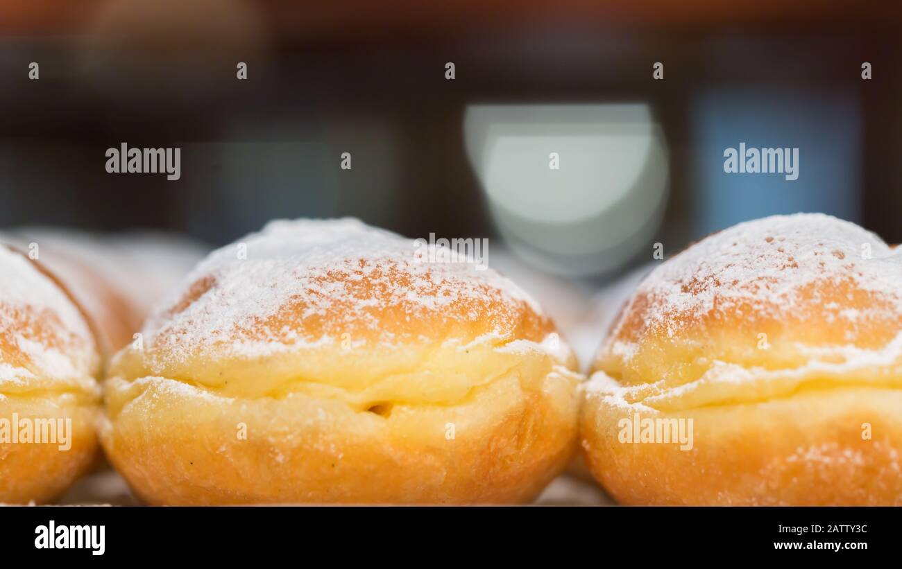 Macro (side shot) of austrian Krapfen (donut). Topped with powdered sugar. Popular in all german speaking countries. In northern parts called Berliner Stock Photo