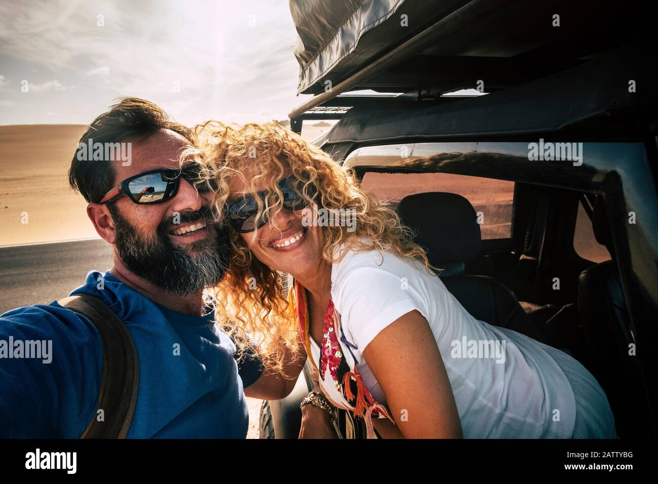 Cheerful adult happy caucasian couple enjoy travel with car and take selfie picture smiling together with friendship and relationship - healthy and fr Stock Photo