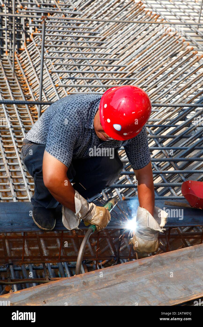 The welding worker in the construction site making reinforcement metal ...