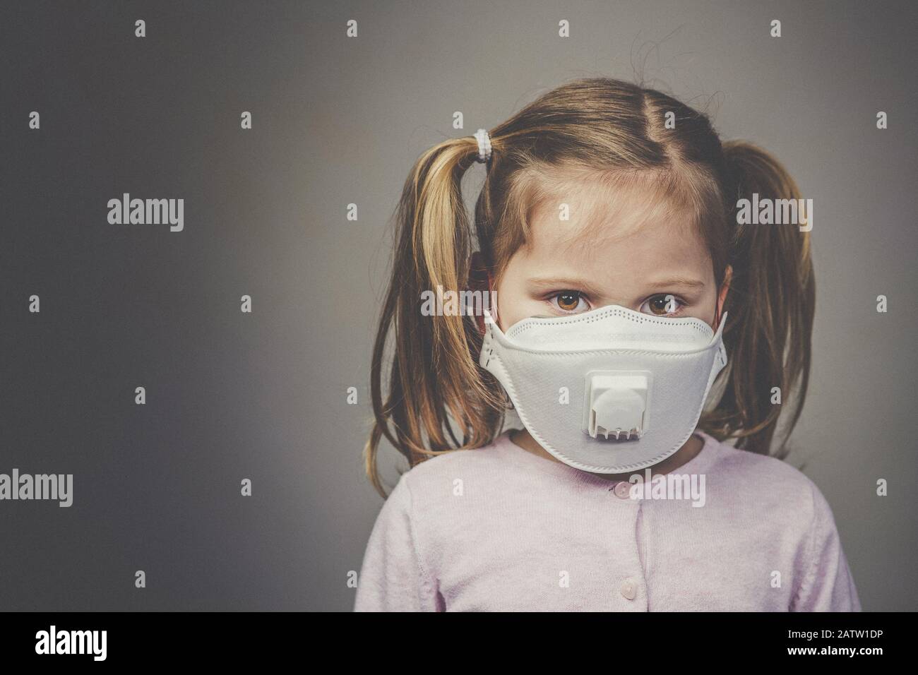 portrait of a girl with pigtails wearing a medical mask to protect herself from the crown virus infection. Stock Photo