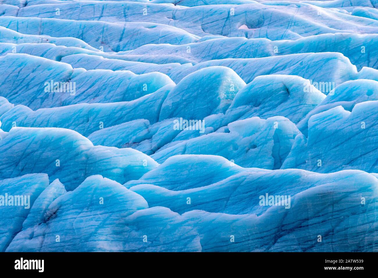Sunlight catches the edges of blue glacial ice at the Svinafellsjokul glacier in southeast Iceland. This is the largest ice cap in Europe. Stock Photo