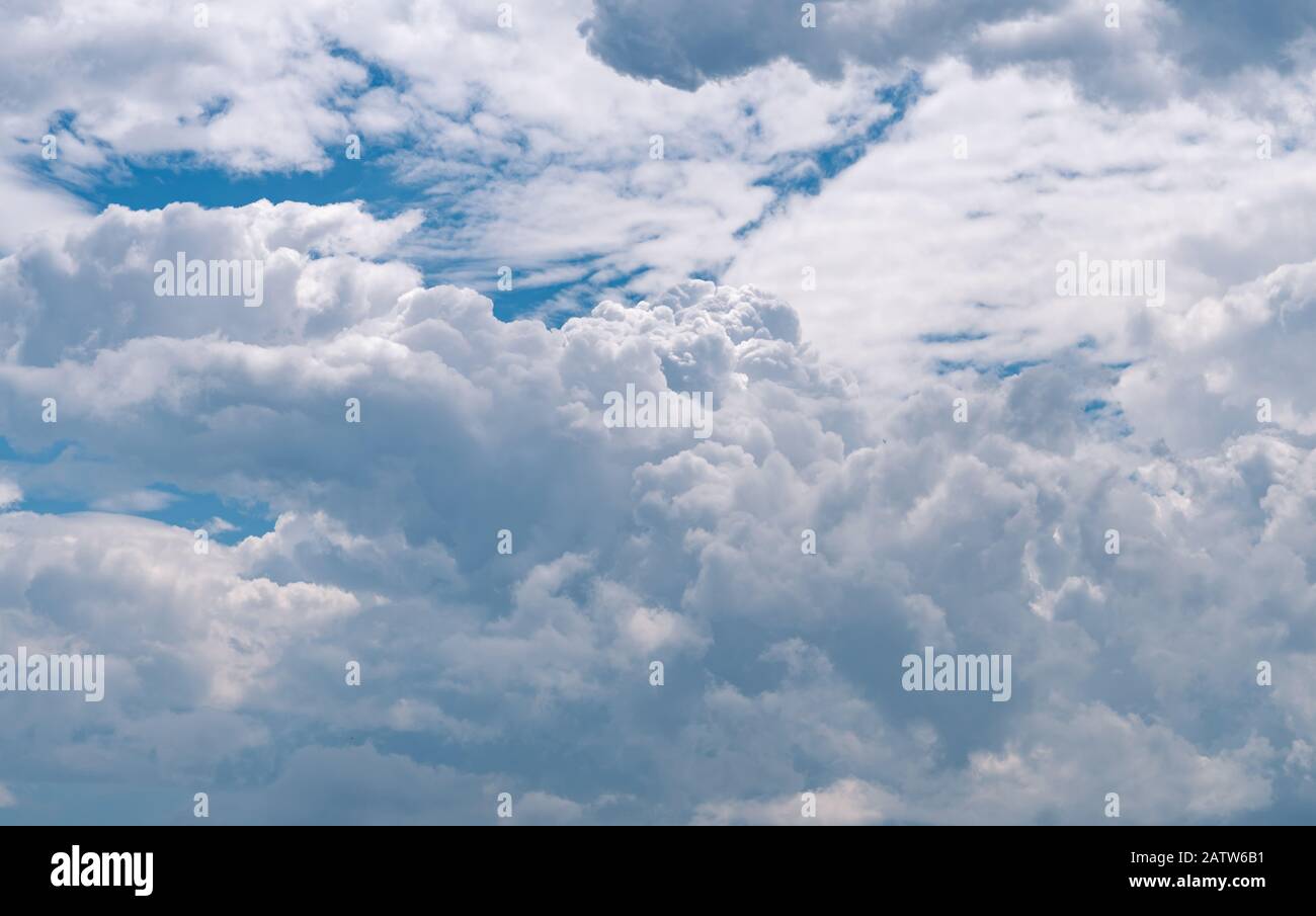 Beautiful blue sky and white cumulus clouds abstract background. Cloudscape background. Blue sky and fluffy white clouds on sunny day. Nature weather. Stock Photo