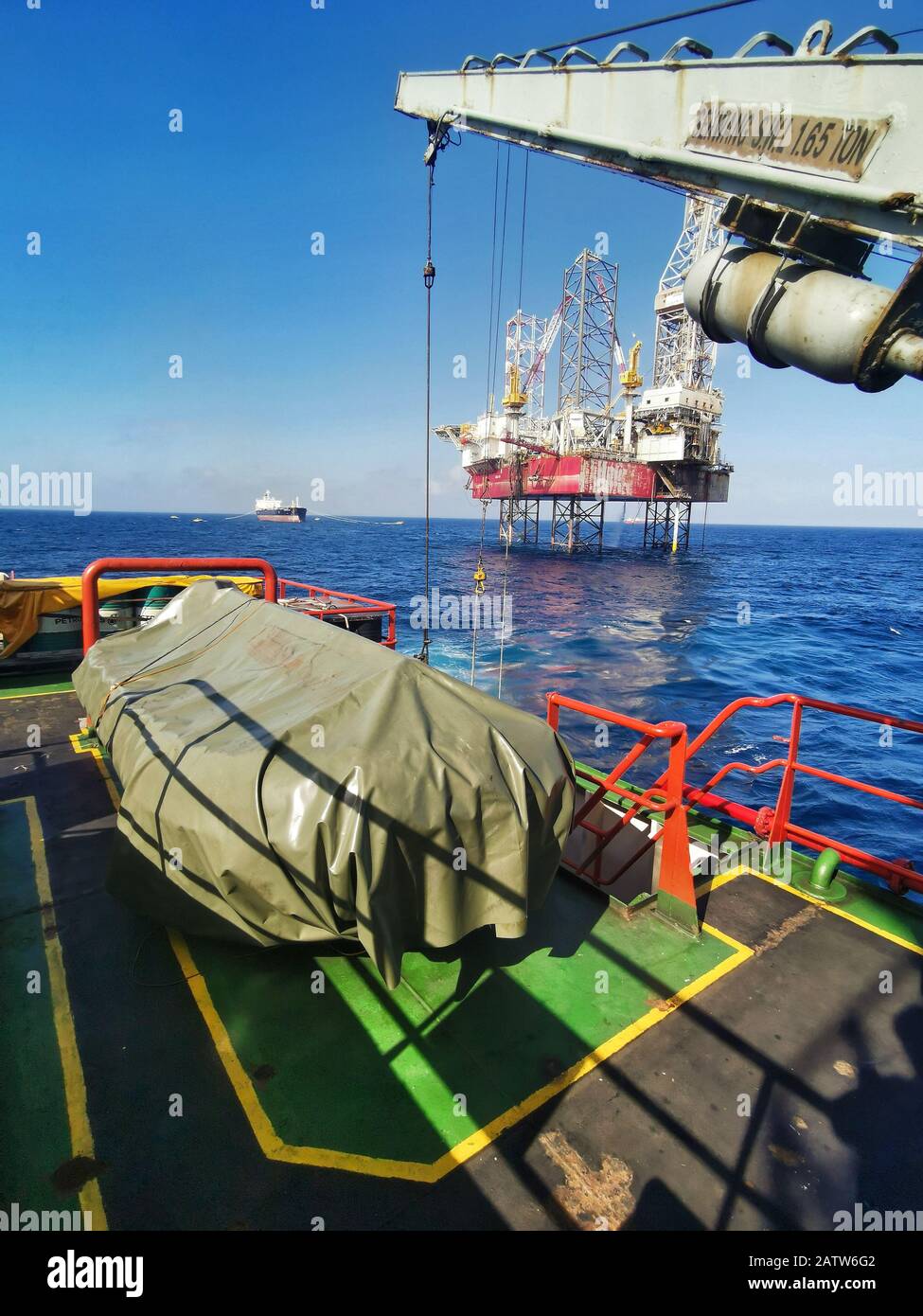 offshore support vessel steaming or roaming near jack up ring for delivering cargo Stock Photo