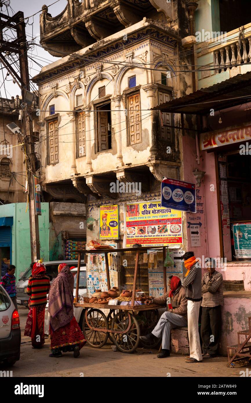 India, Rajasthan, Shekhawati, Ramgarh, main street, customers at shop in old street corner haveli Stock Photo