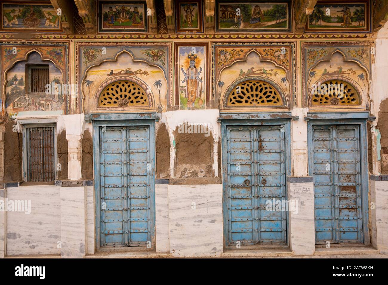 India, Rajasthan, Shekhawati, Ramgarh, blue painted doors of well-maintained old haveli, with lower decorative painted whitewashed over Stock Photo