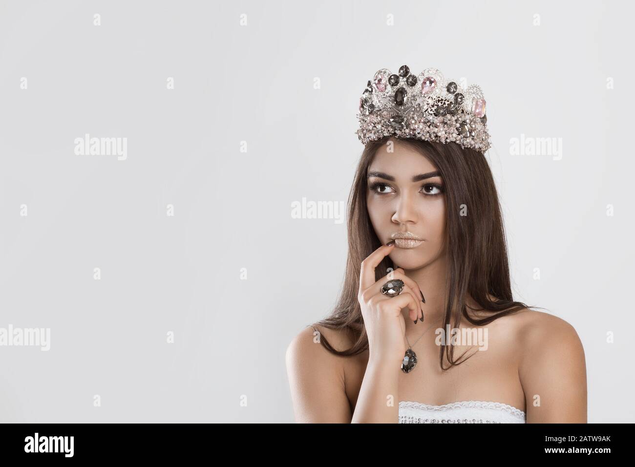 https://c8.alamy.com/comp/2ATW9AK/thinking-about-miss-contest-beauty-crowned-queen-girl-woman-actress-miss-hand-on-chin-face-daydreaming-planning-looking-to-side-isolated-white-wall-f-2ATW9AK.jpg