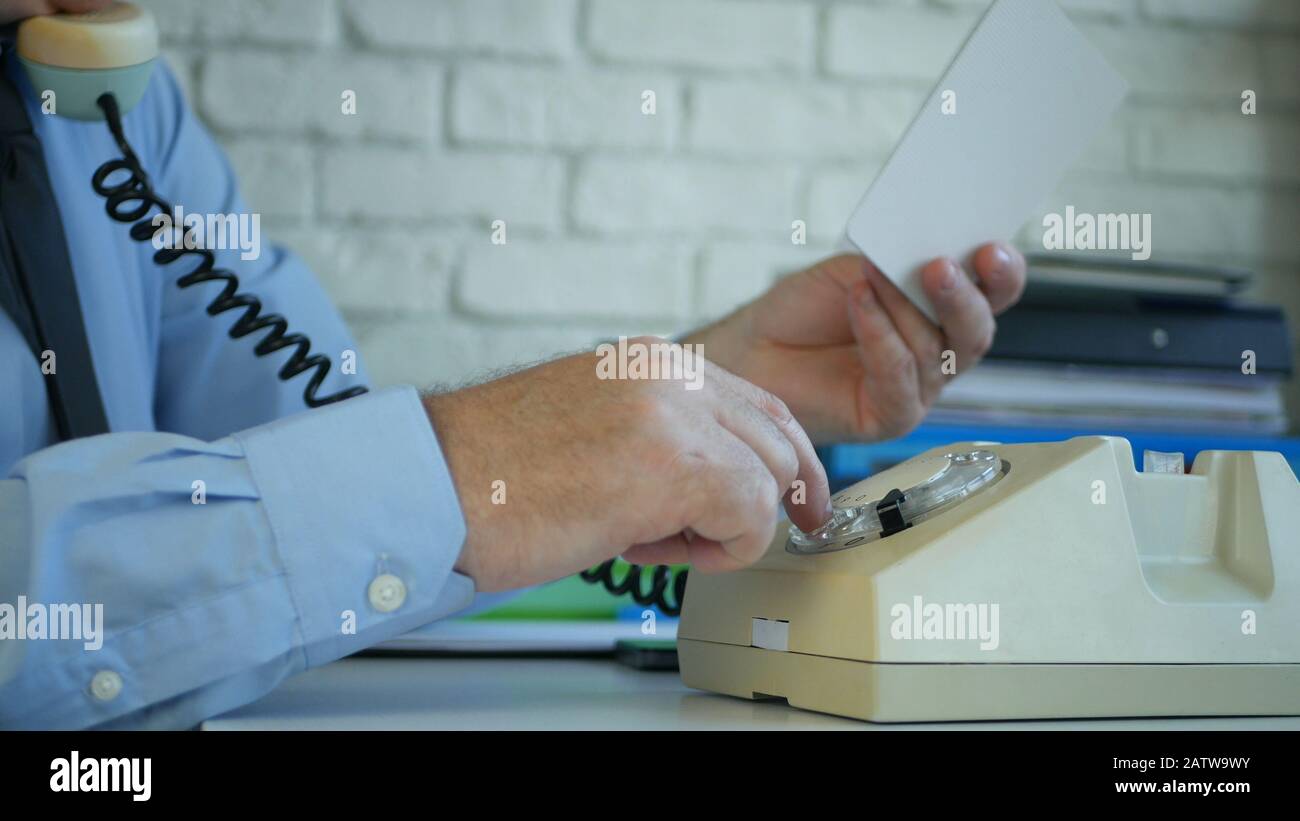 Businessman Working in Office Making a Phone Call from an Old Telephone Stock Photo
