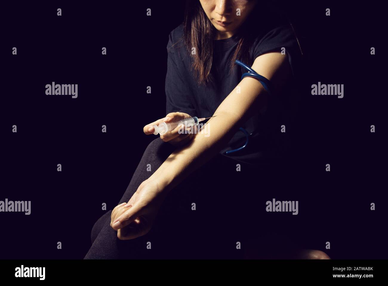 drug addict woman use syringe injecting drugs in her arm. drugs addict concept Stock Photo