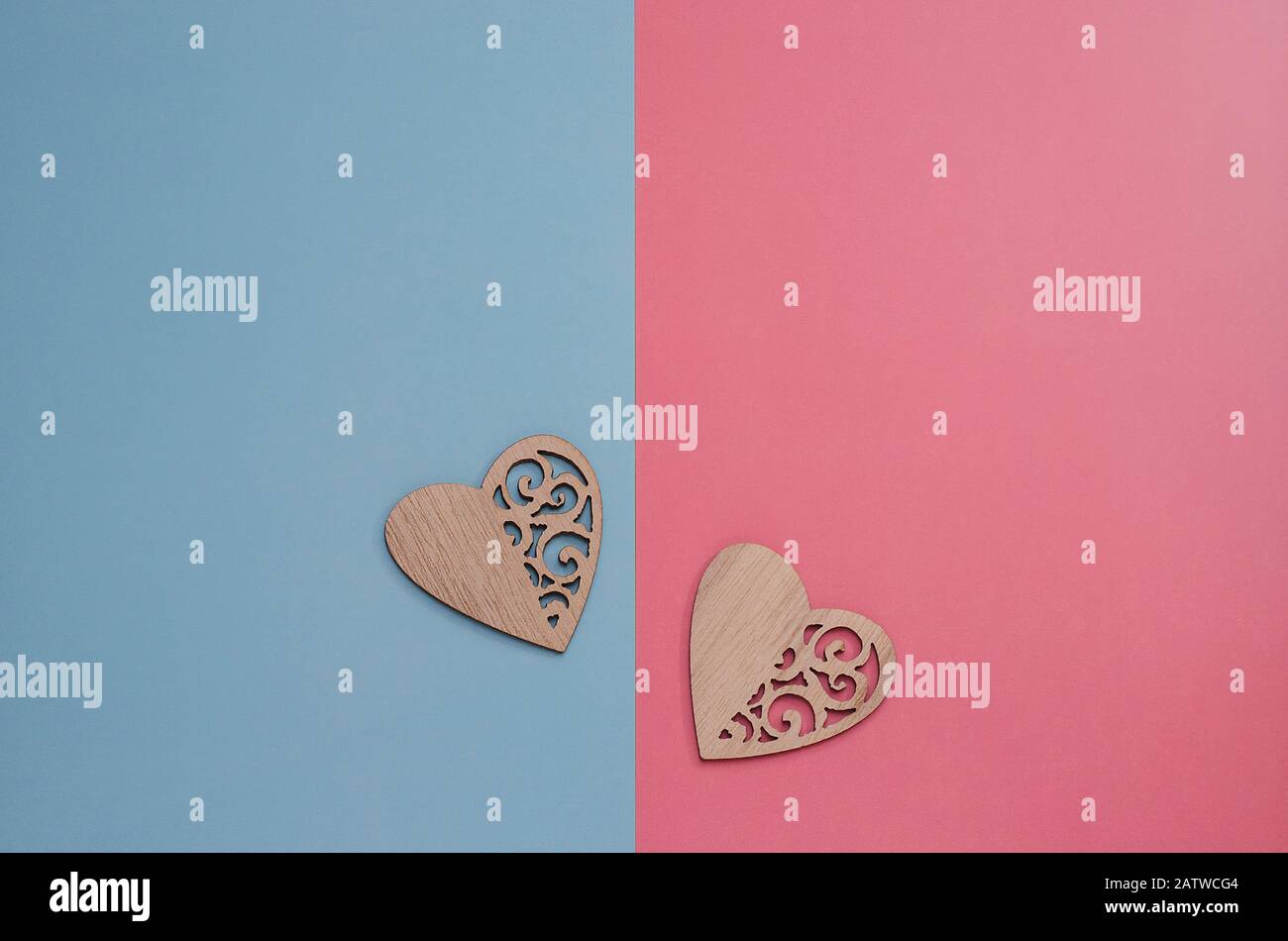 Two wooden carved hearts on a pink and blue background with copy space. Background minimalism for Valentine's Day, Mother's Day, Birth of a child. Pos Stock Photo