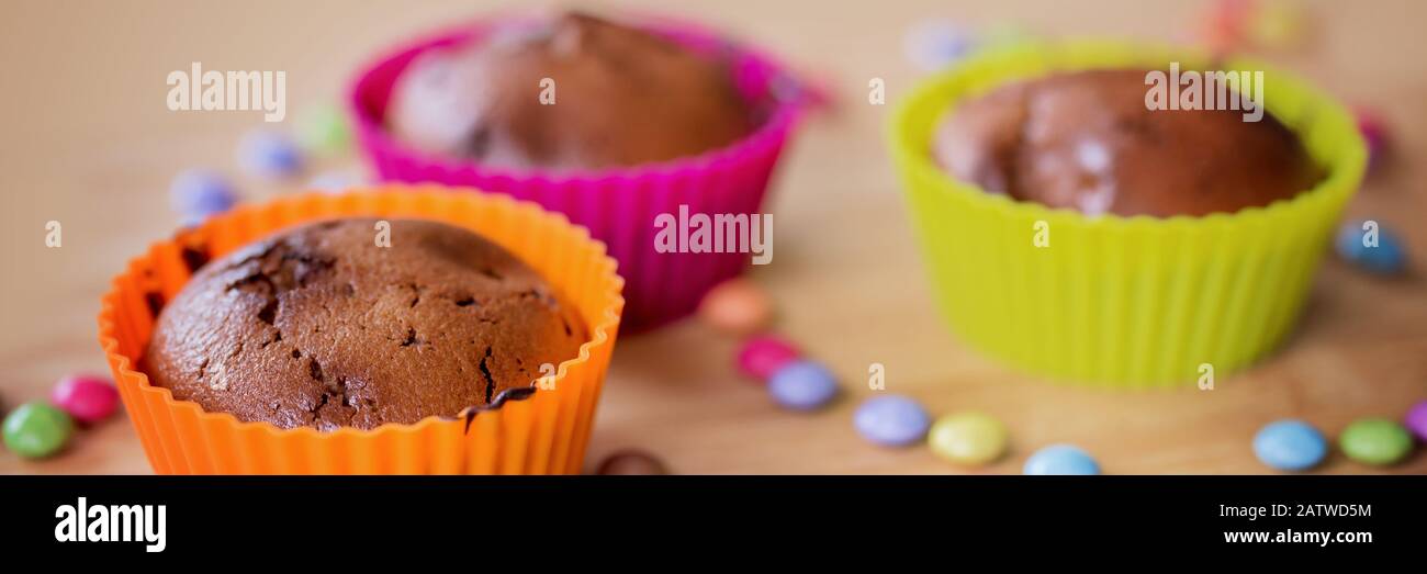 Colorful chocolate cupcakes with sweets, panoramic food web banner Stock Photo