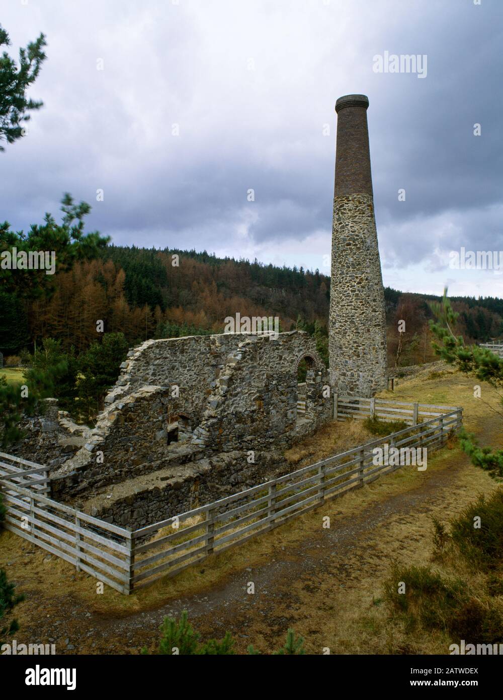 View NE of the engine house, 18m-high stack & winding drum pit of Llanrwst Lead Mine in Gwydir Forest, North Wales, UK: engine house built 1876-77. Stock Photo