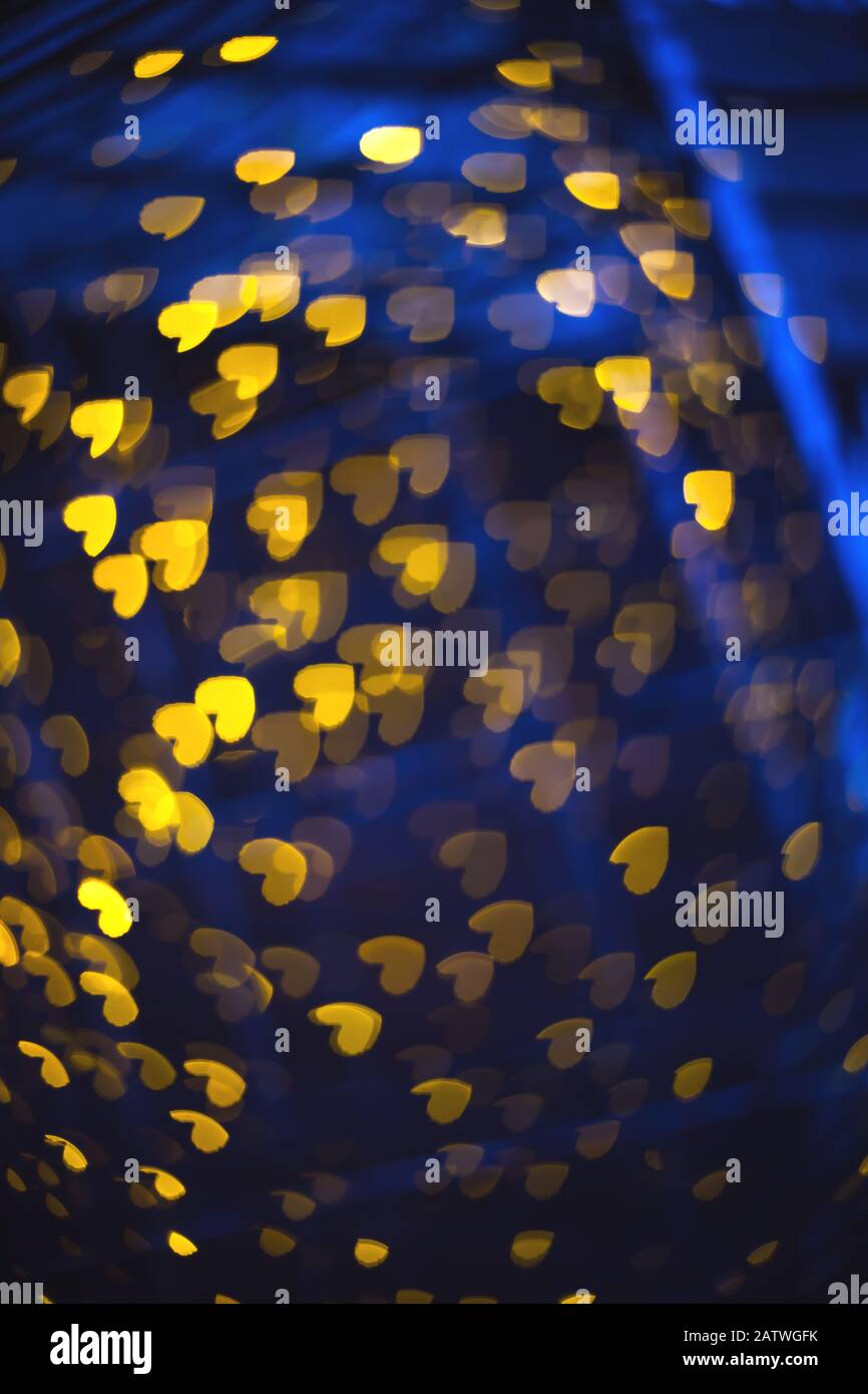 Blurred background with glowing hearts shape bokeh lights. De focus abstract romantic shiny backdrop. Valentines day blurry pattern Stock Photo
