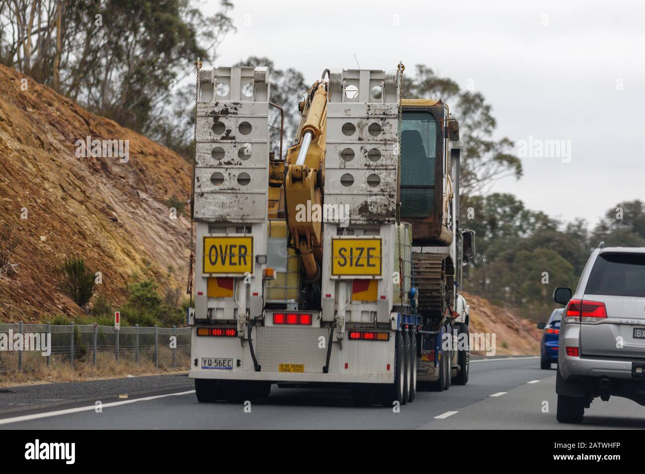 oversize vehicle with excavator driving on the hume highway in australia Stock Photo