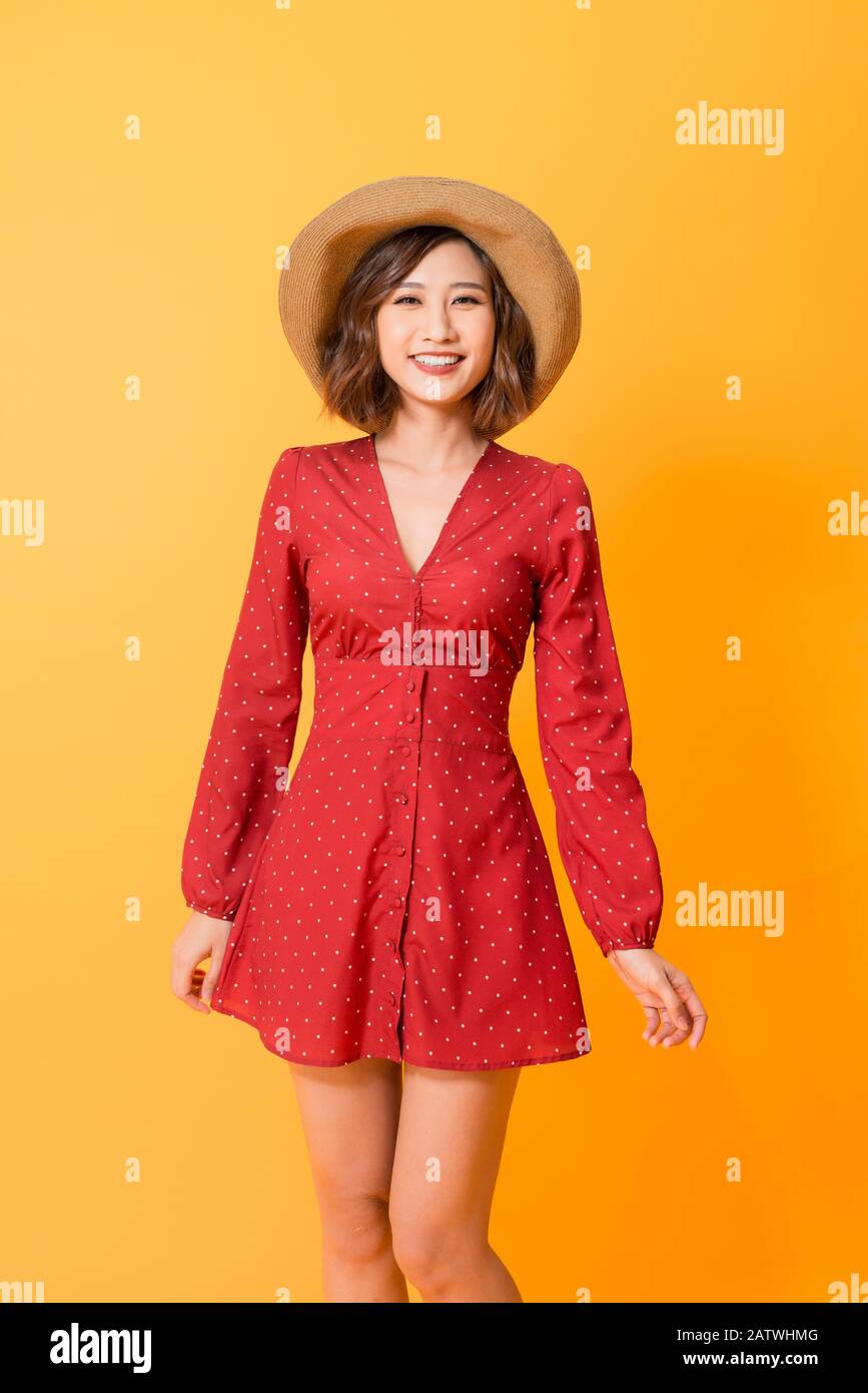 Portrait of young beautiful asian woman wear red dress and hat over ...