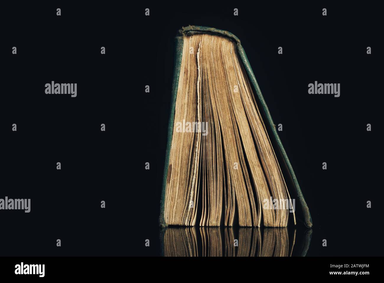 Ancient book shot on black background. The book is in bad condition ...