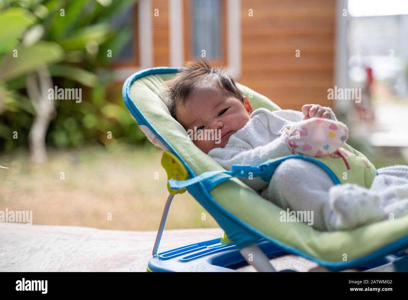 newborn infant on baby bouncer at home Stock Photo