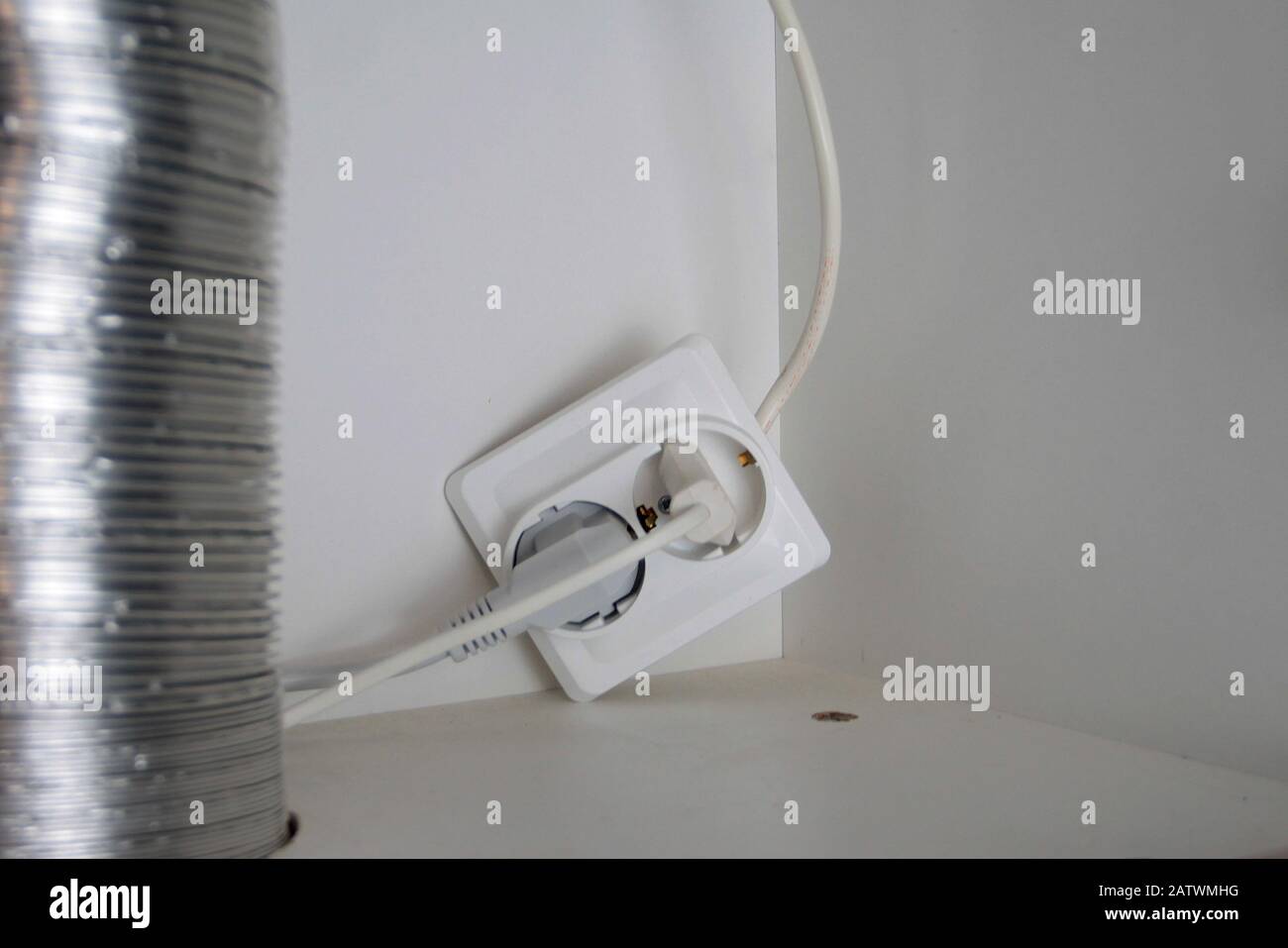 Two electrical plugs are plugged into a broken outlet Stock Photo Alamy