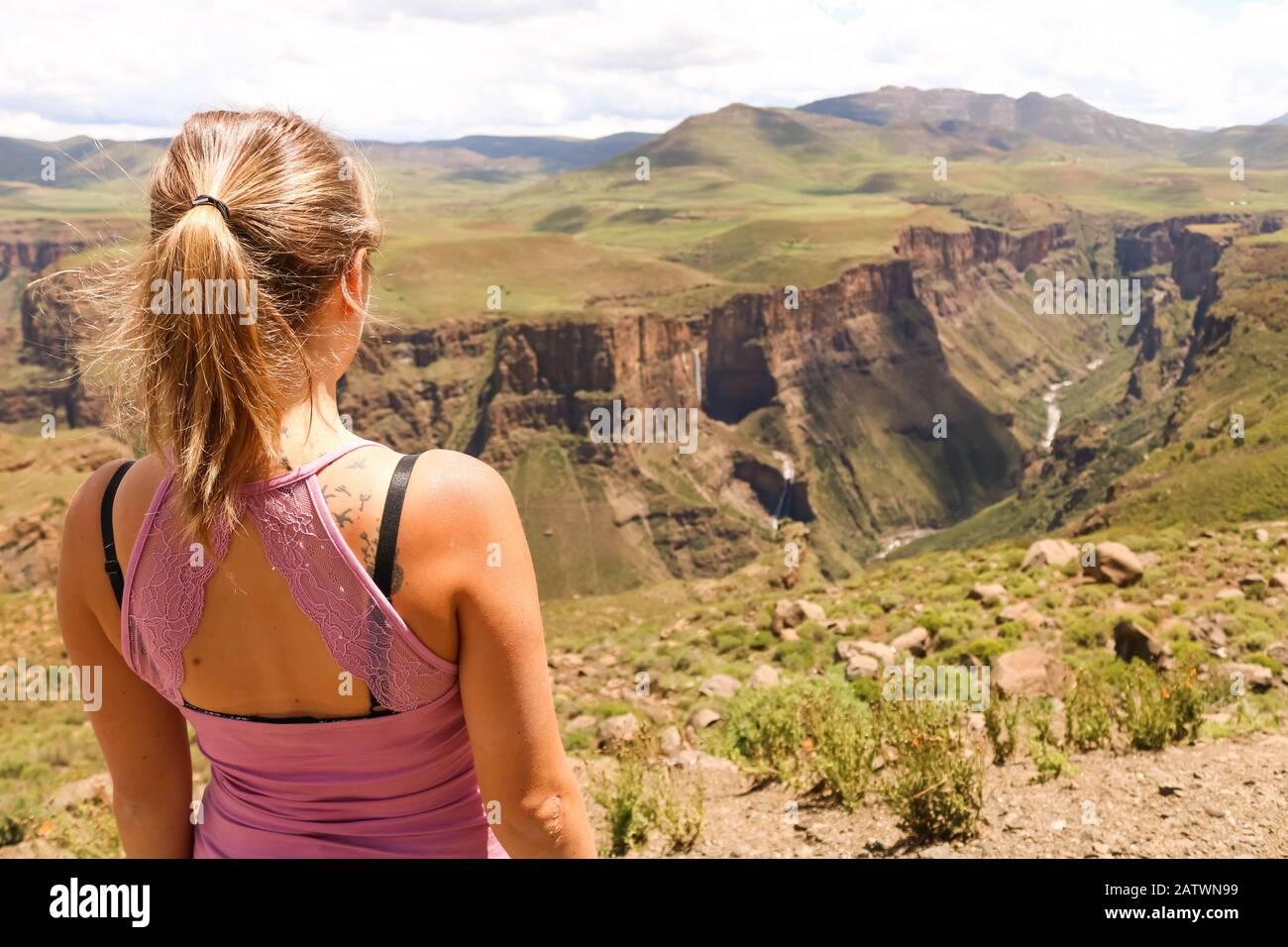 female hiking tourist at the edge of a cliff overlooking the canyons Stock Photo