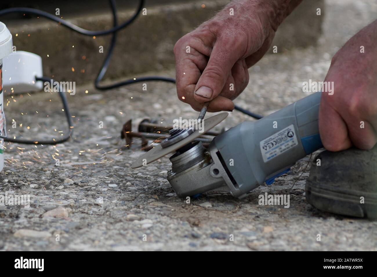 Man is sharpening nail on the grinding machine Stock Photo
