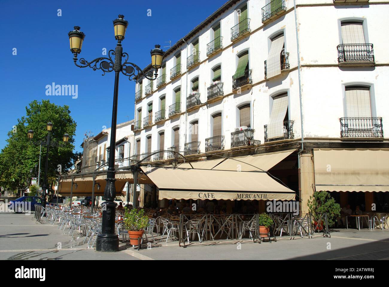Pavement cafe in the Plaza de la Constitucion with a traditional Spanish streetlight in the