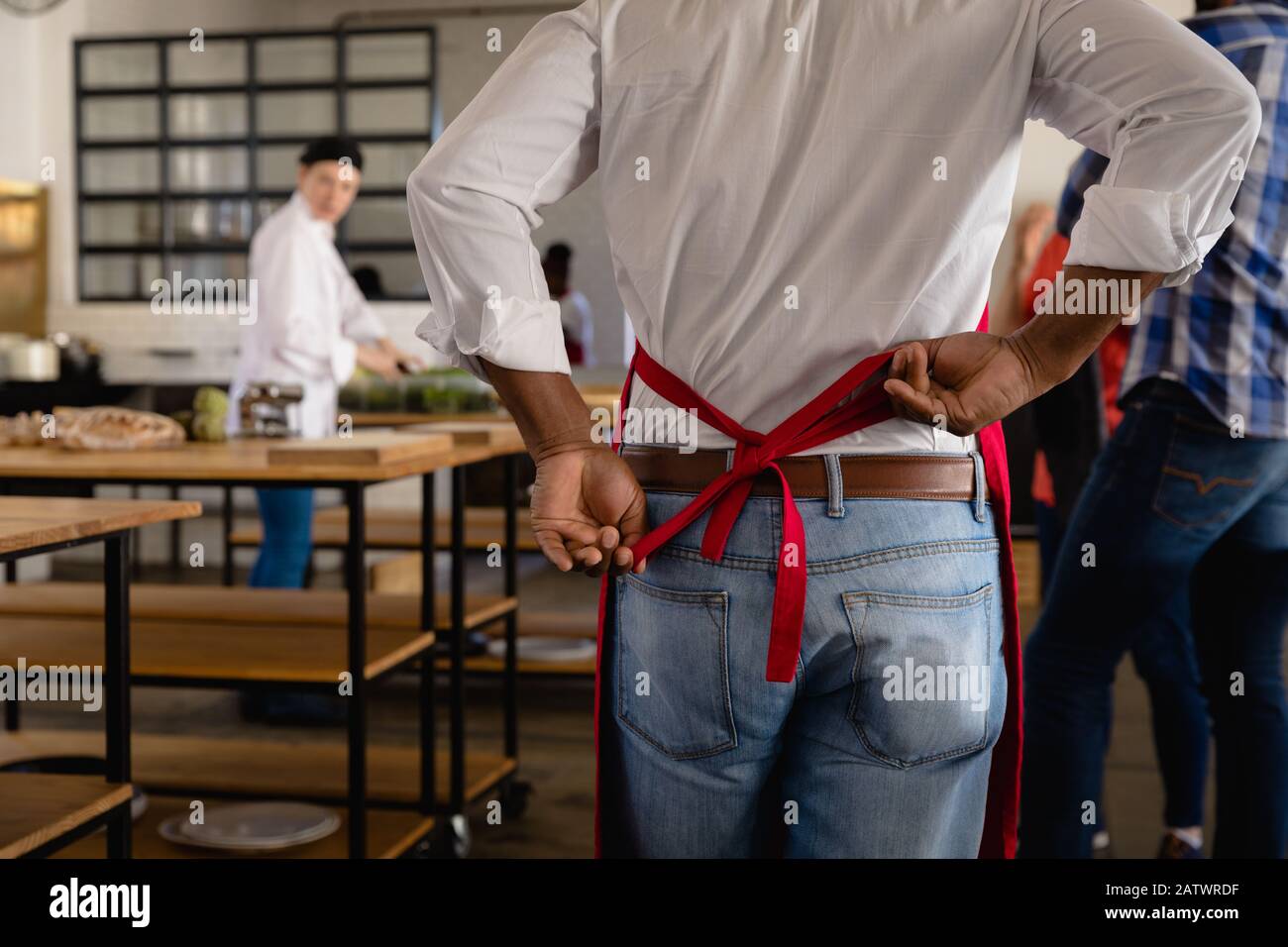 African man putting on his cooks apron Stock Photo
