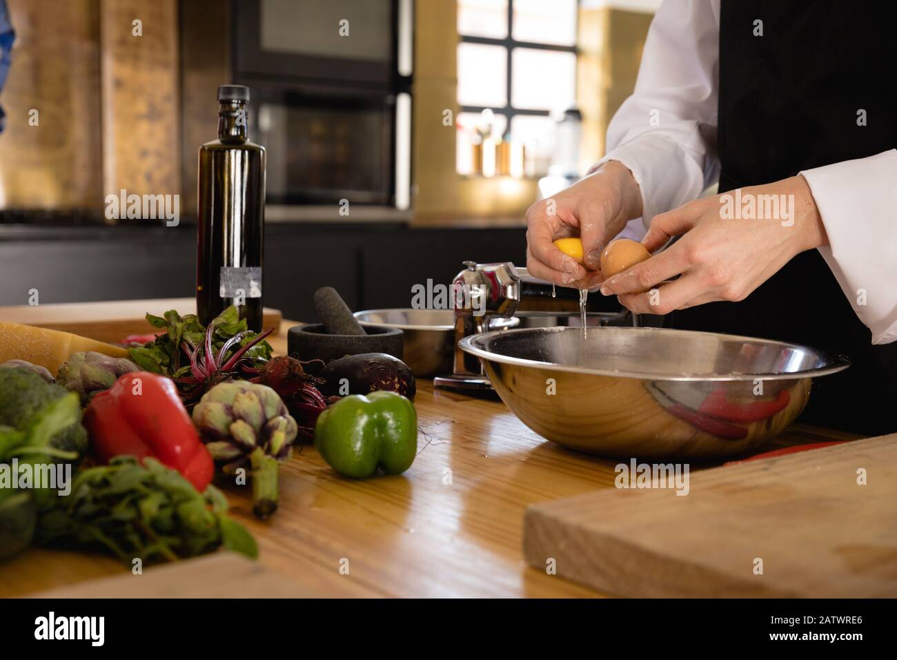 Chef putting an egg in a bowl Stock Photo