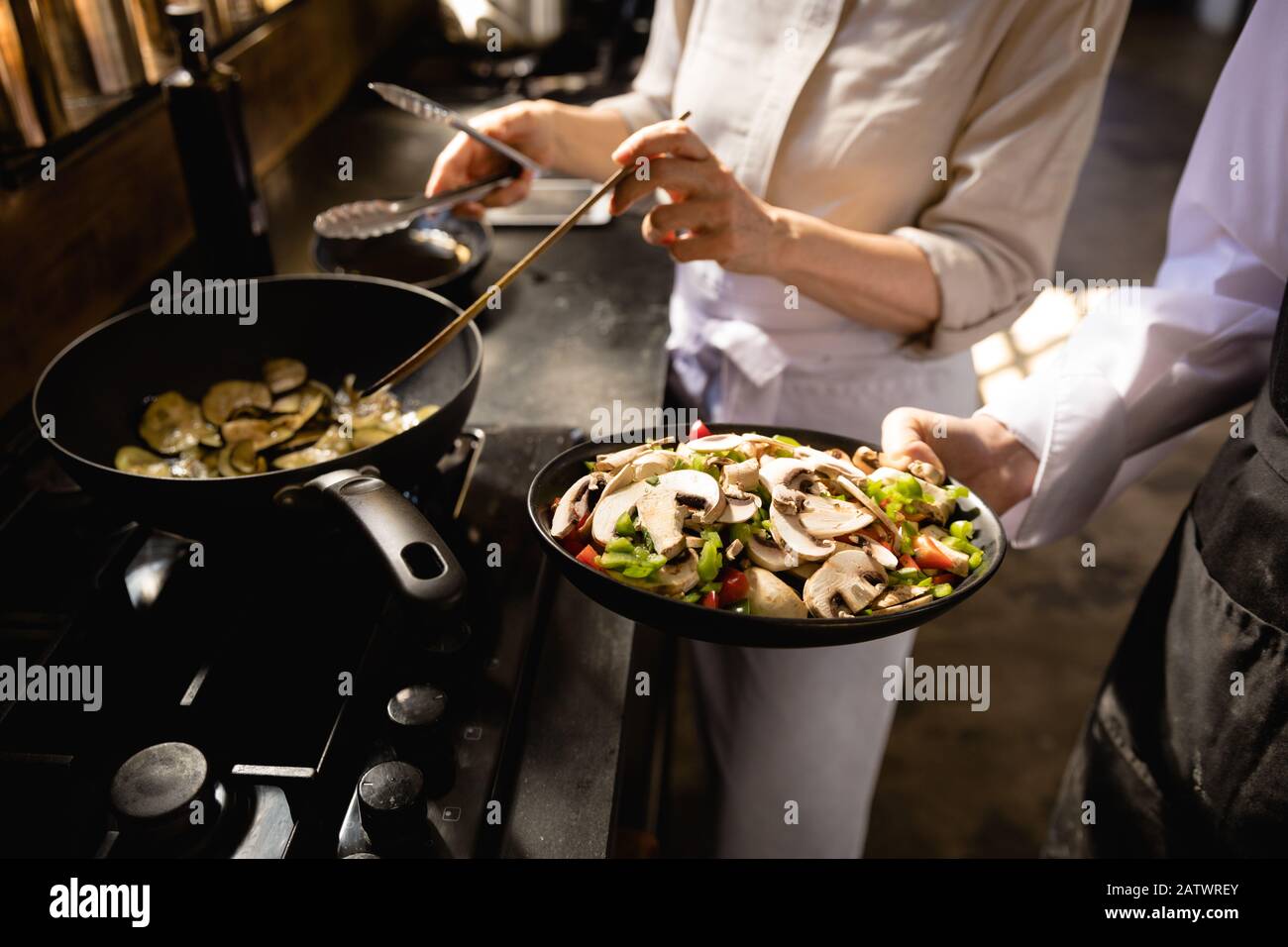 Caucasian chefs cooking vegetables Stock Photo