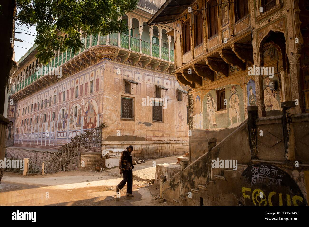 India, Rajasthan, Shekhawati, Dundlod, man walking between old painted Havelis Stock Photo