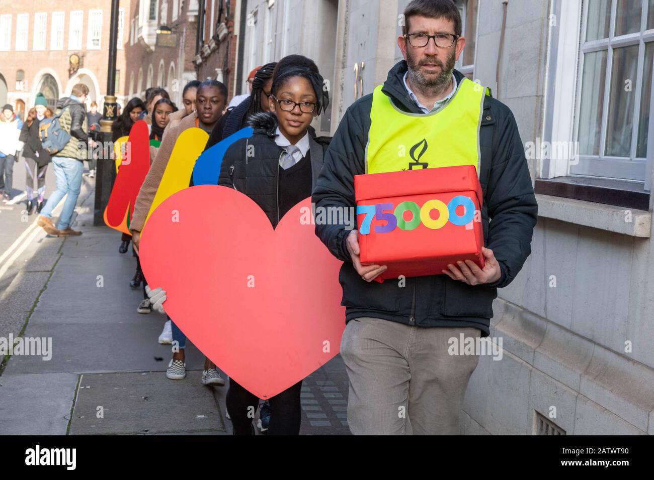 London, UK. 5th Feb, 2020. Amnesty International holds a demonstration outside Westminster to protest the Government's 'destructive' refugee reunion laws. The demonstration, which includes school children, activists and refugees, features a banner with multi-coloured lettering saying 'families belong together', and is followed up by activists handing in a 70,000-strong petition to the Home Office. Credit: Ian Davidson/Alamy Live News Stock Photo