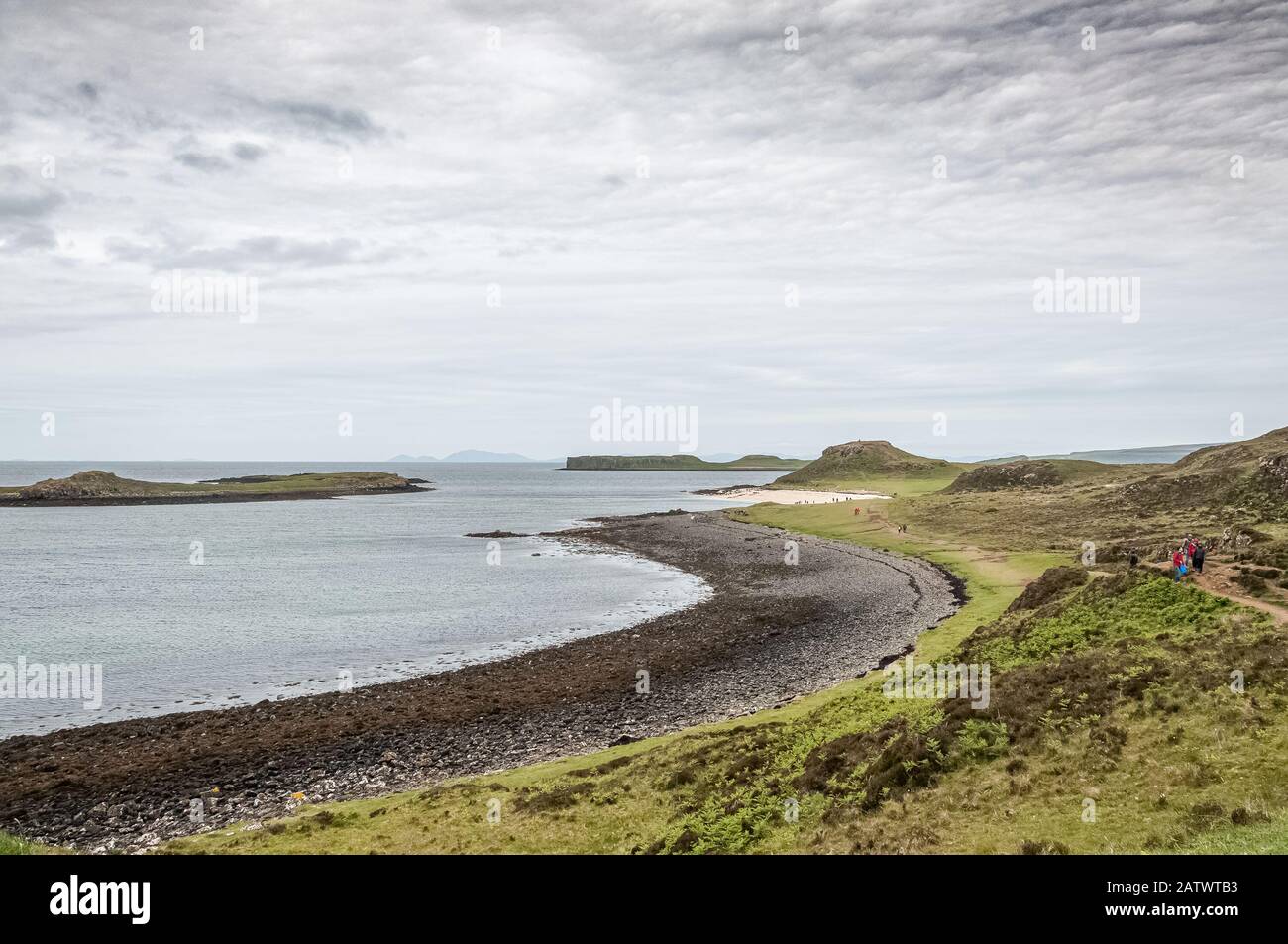 Unrecognizable people walking along white and black beaches, Isle of Skye Stock Photo