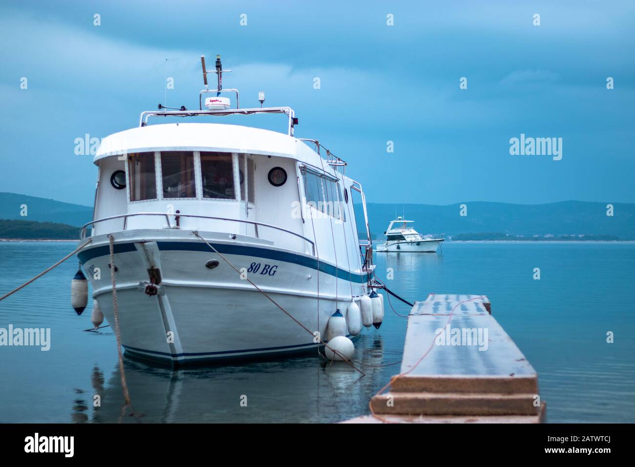 Big Croatian traditional fishing boat anchored on a small stone pier Stock Photo