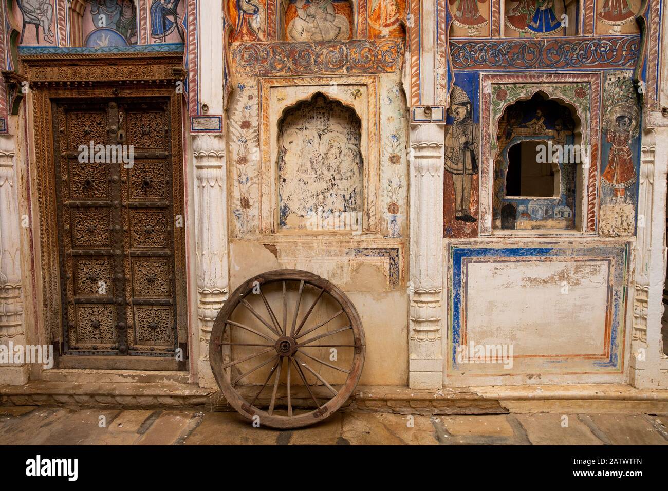 India, Rajasthan, Shekhawati, Dundlod, Tunanram Goenka (seth rus Das) Haveli, restored home of wealthy merchant, courtyard, wheel between decorated do Stock Photo