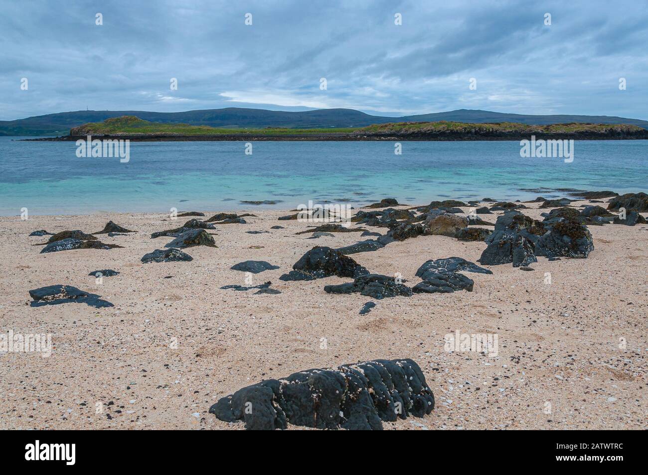 Black boulders on white beach, Coral Beach, Isle of Skye, Scotland Stock Photo