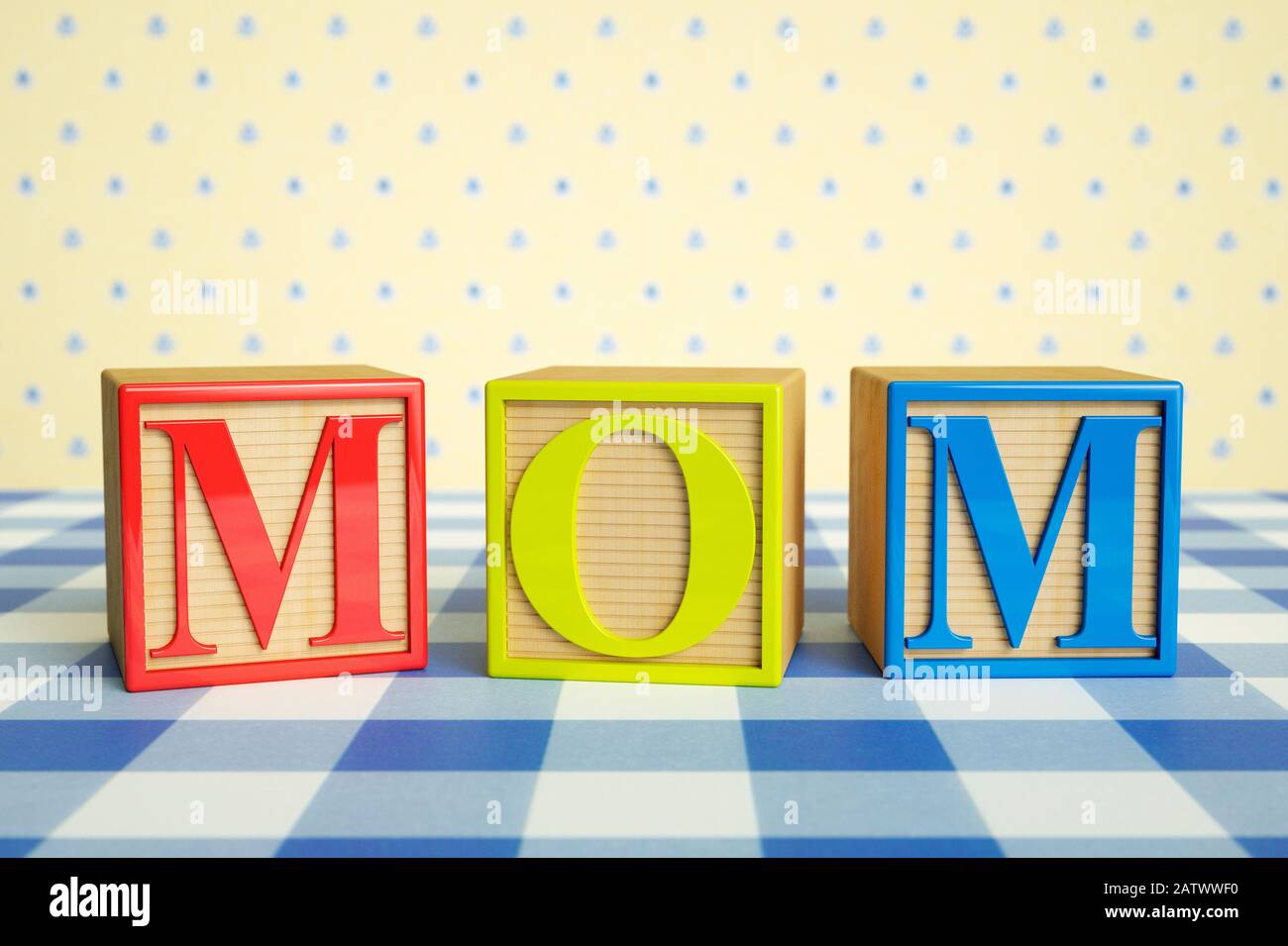 Childrens wooden ABC blocks spelling MOM on a checked tablecloth Stock Photo