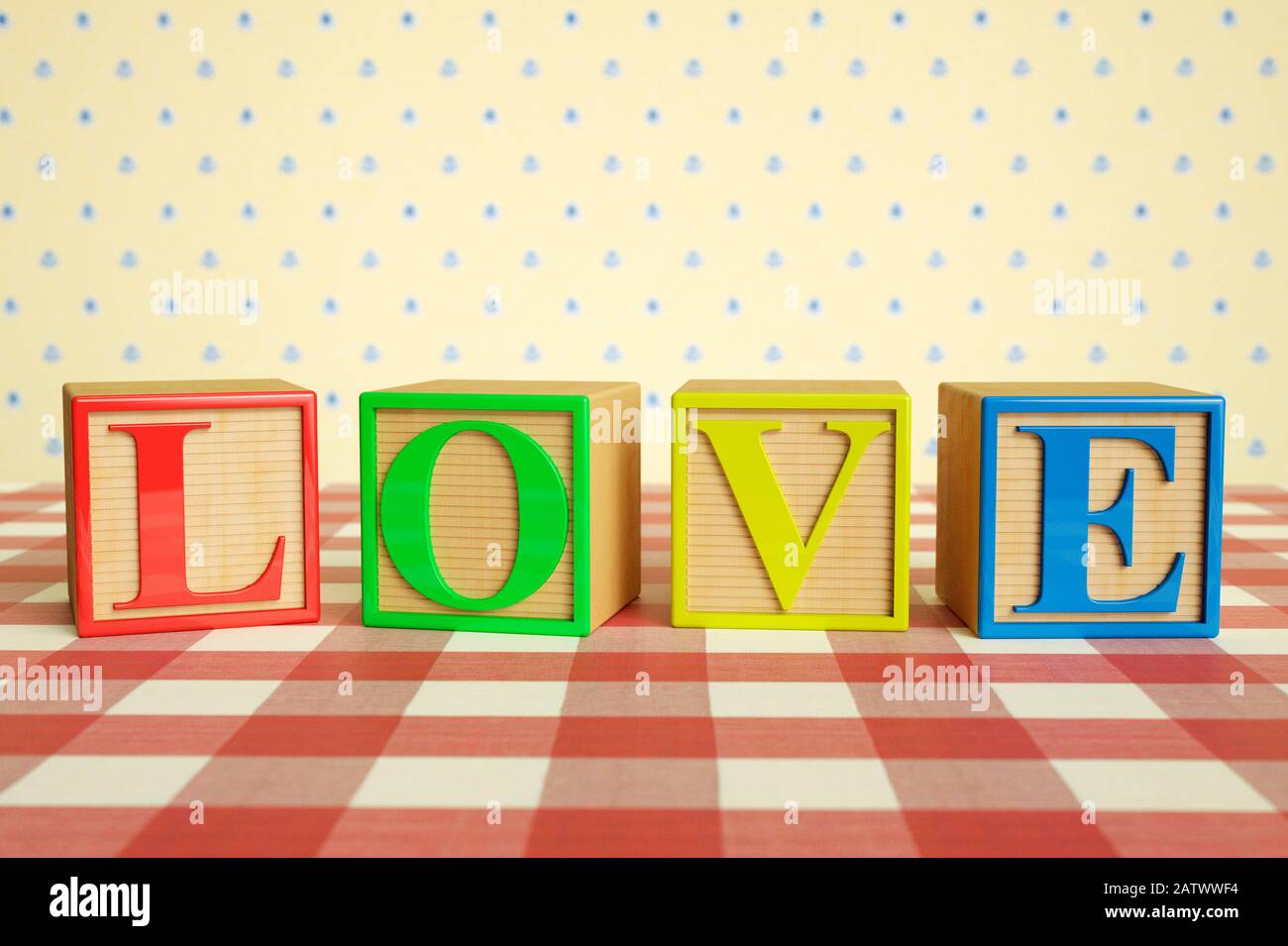 Childrens wooden ABC blocks spelling LOVE on a checked tablecloth Stock Photo