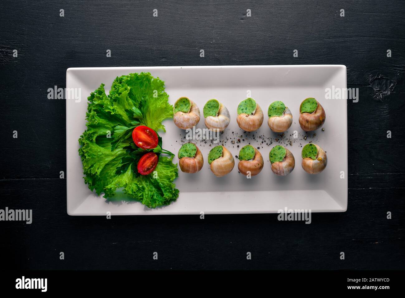 French and Italian cuisine. Baked snails. On a wooden background. Top view. Free space Stock