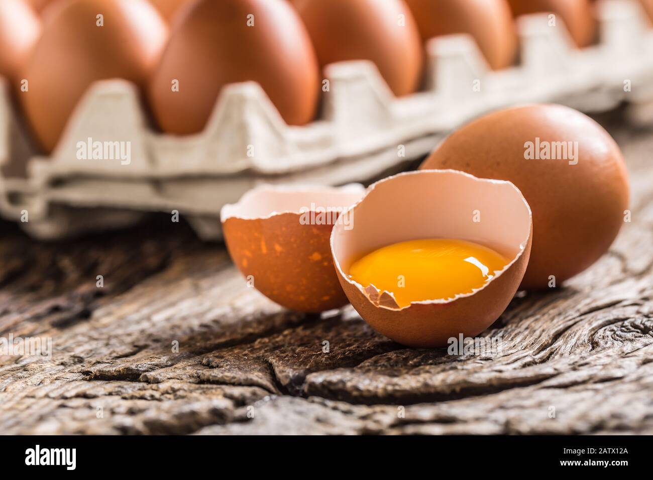Chicken eggs in carton box on rustic wooden table Stock Photo