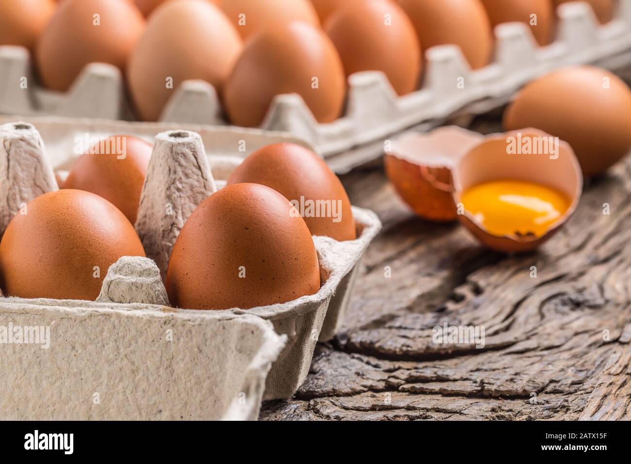 Chicken eggs in carton box on rustic wooden table Stock Photo