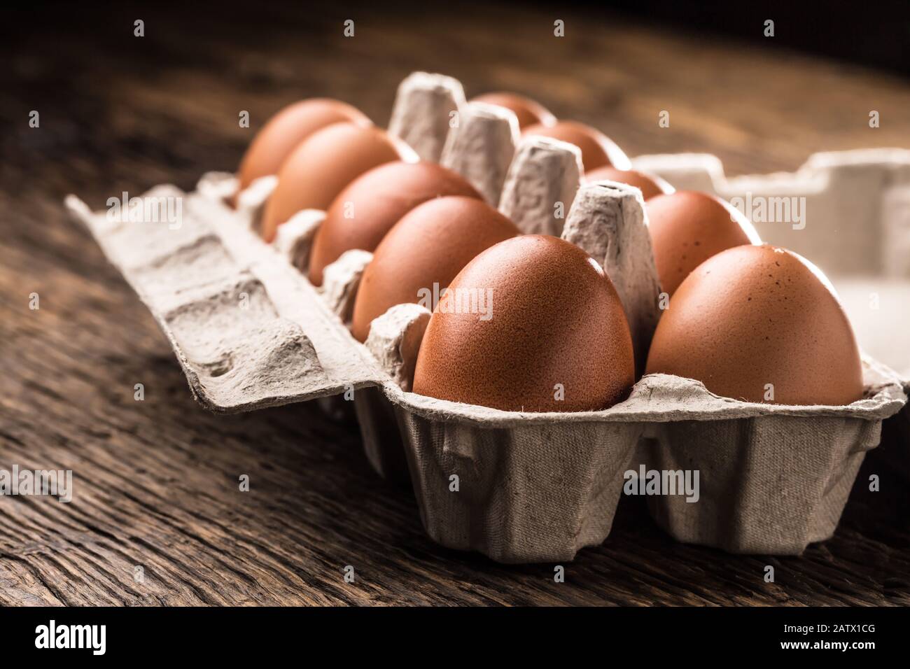 Chicken eggs in carton box on rustic wooden table Stock Photo