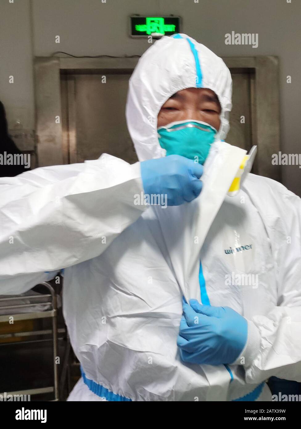 Wuhan. 5th Feb, 2020. Photo taken with a mobile phone on Feb. 5, 2020 shows Peng Zhiyong, the director of the intensive care unit, putting on protective suit before treating patient at the preparation area of the isolation ward in Zhongnan Hospital of Wuhan University in Wuhan, central China's Hubei Province. Credit: Zhong Nanxuan/Xinhua/Alamy Live News Stock Photo