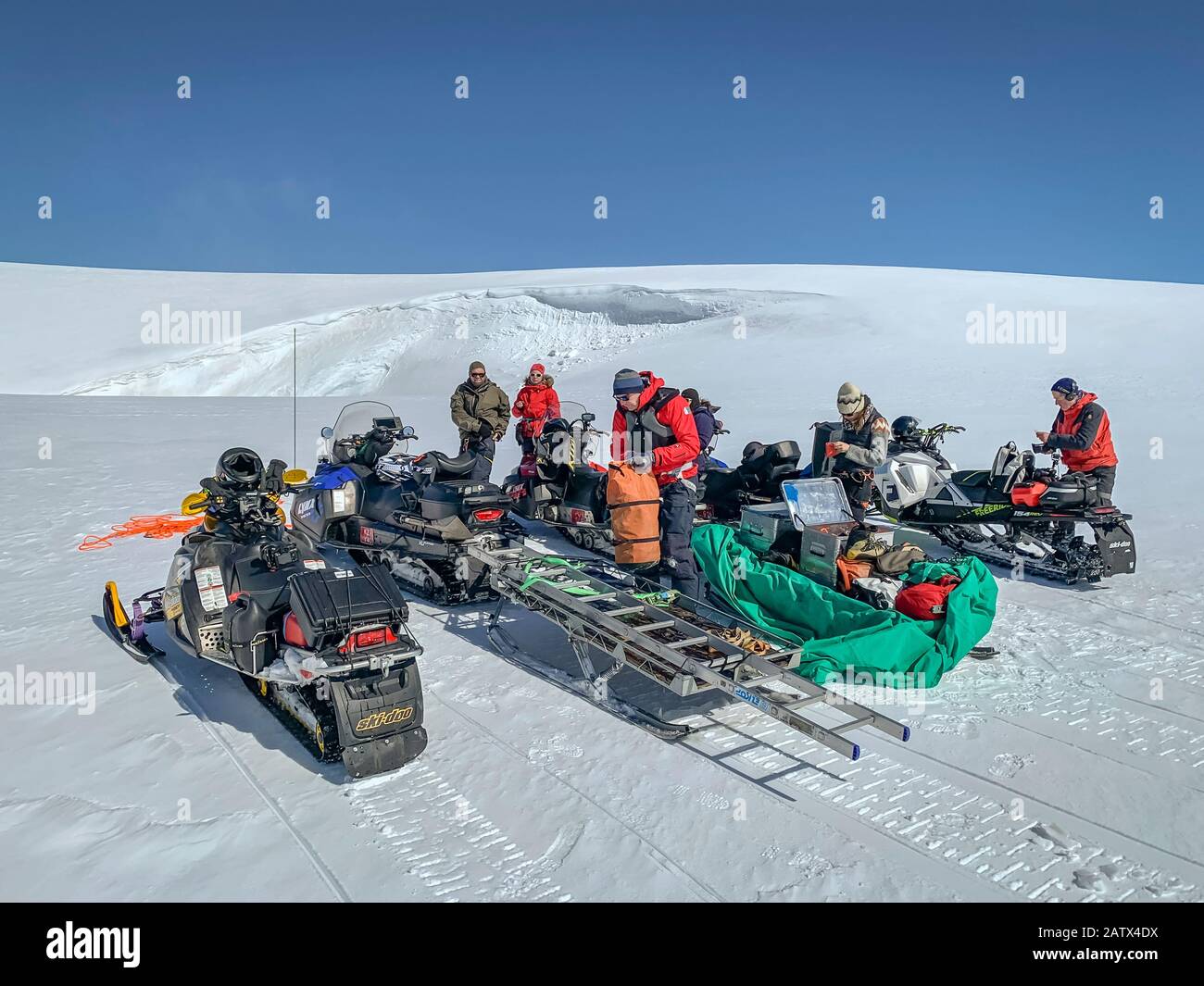 Scientists with snowmobiles on a glacial trip to take samples and measurements, Vatnajokull Ice Cap, Vatnajokull National Park, Iceland. Stock Photo