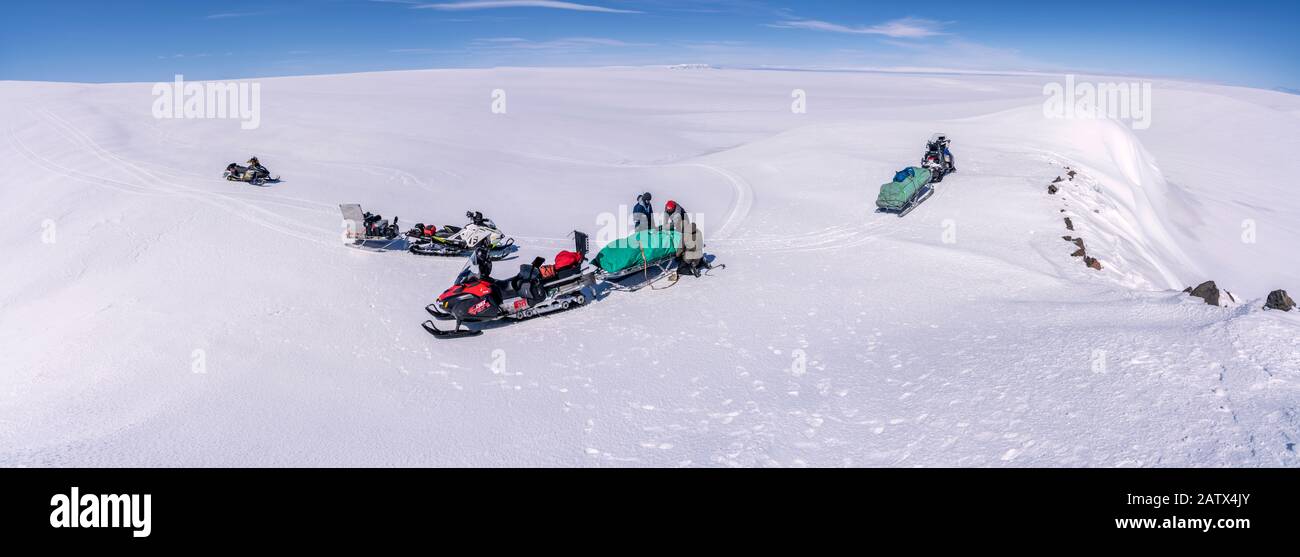 Scientists with snowmobiles on a glacial trip to take samples and measurements, Vatnajokull Ice Cap, Vatnajokull National Park, Iceland. Stock Photo