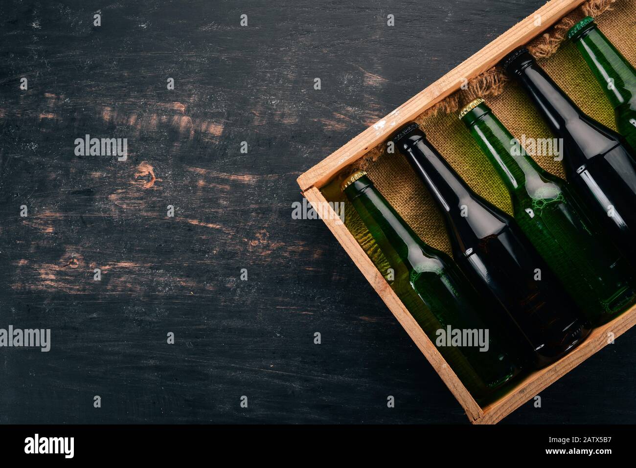 A set of beer in a wooden box. On a wooden background. Free space for ...