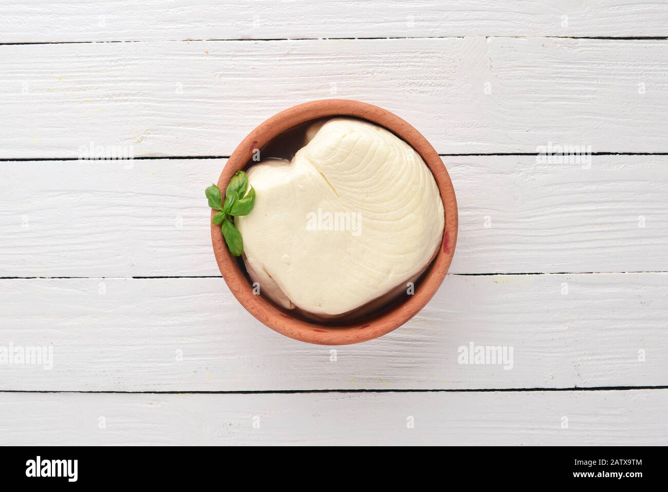 Brynza Cheese from sheep's milk. Top view. On a white wooden background. Free copy space. Stock Photo