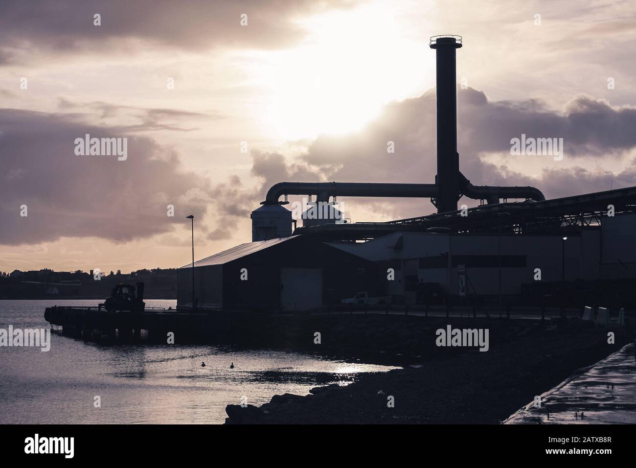 Silhouette industrial landscape with a factory on seacoast, Norway Stock Photo