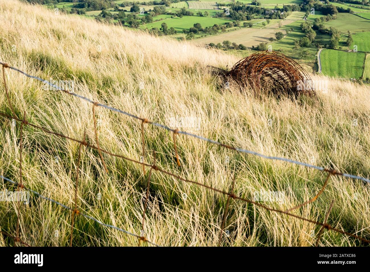 Rubbish in the countryside. An unwanted roll of rusting wire fencing discarded and left on farmland, The Great Ridge, Derbyshire, England, UK Stock Photo