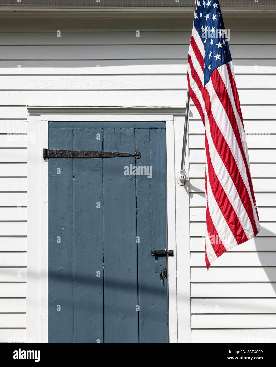American flag and colonial cottage. Stock Photo